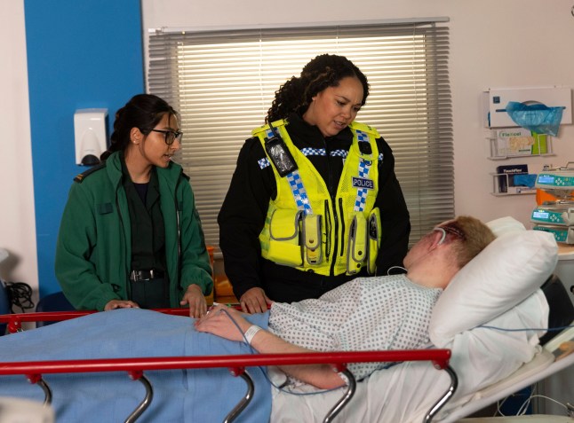 Asha Alahan and Jess Heywood standing over Craig Tinker in a hospital bed