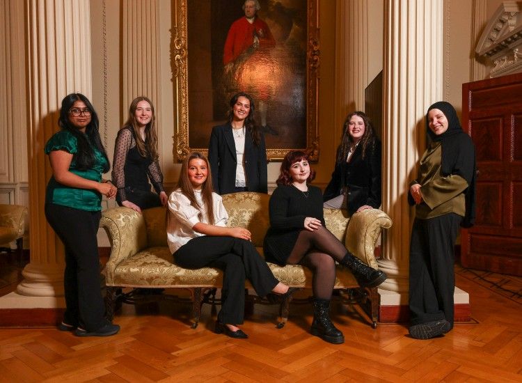 Group of young women pose in formal setting