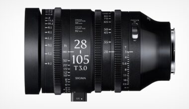 A black Sigma 28-105mm T3.0 cine zoom lens is shown from the side, displaying focus, zoom, and aperture rings with measurement markings, and a lever for adjusting settings.