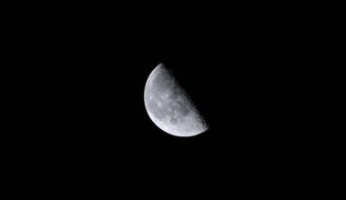 A close up of the moon in the darkness of space, with its top right half obscured in shadow