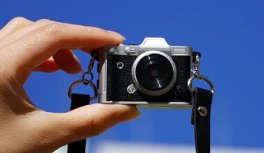 Haru Mini Retro camera being held by fingertips in front of a blue sky