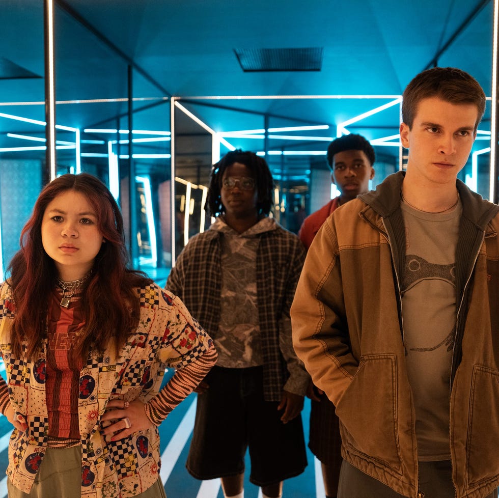 group of young individuals posing in a mirrored room with blue lighting