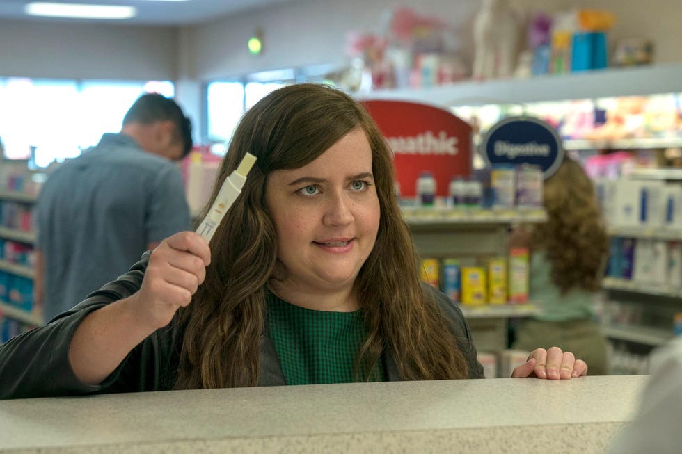 Aidy Bryant as Annie Easton with pregnancy test in shop, Shrill