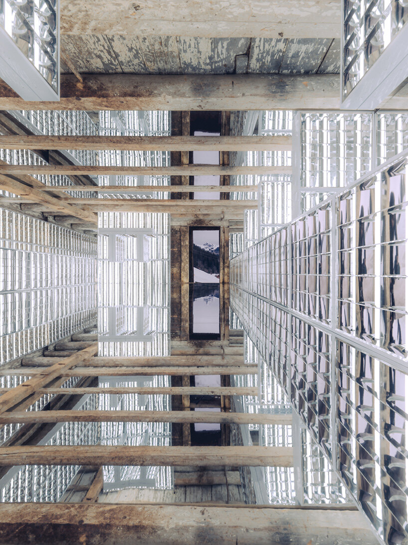 alexandre de betak inserts reflective light installation into traditional swiss barn