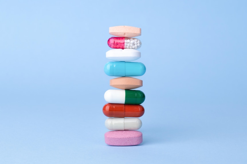 Assorted pharmaceutical drugs balancing on each other.