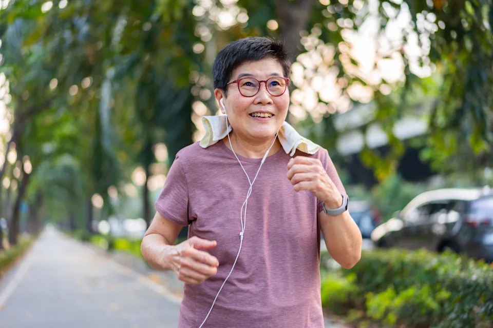 A woman wearing earphones while jogging for exercise. (Photo via Getty Images)