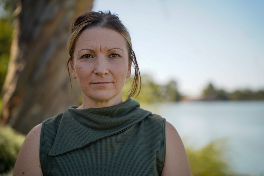 A woman, Nicola Centofanti MLC, wearing a green shirt in front of the river.