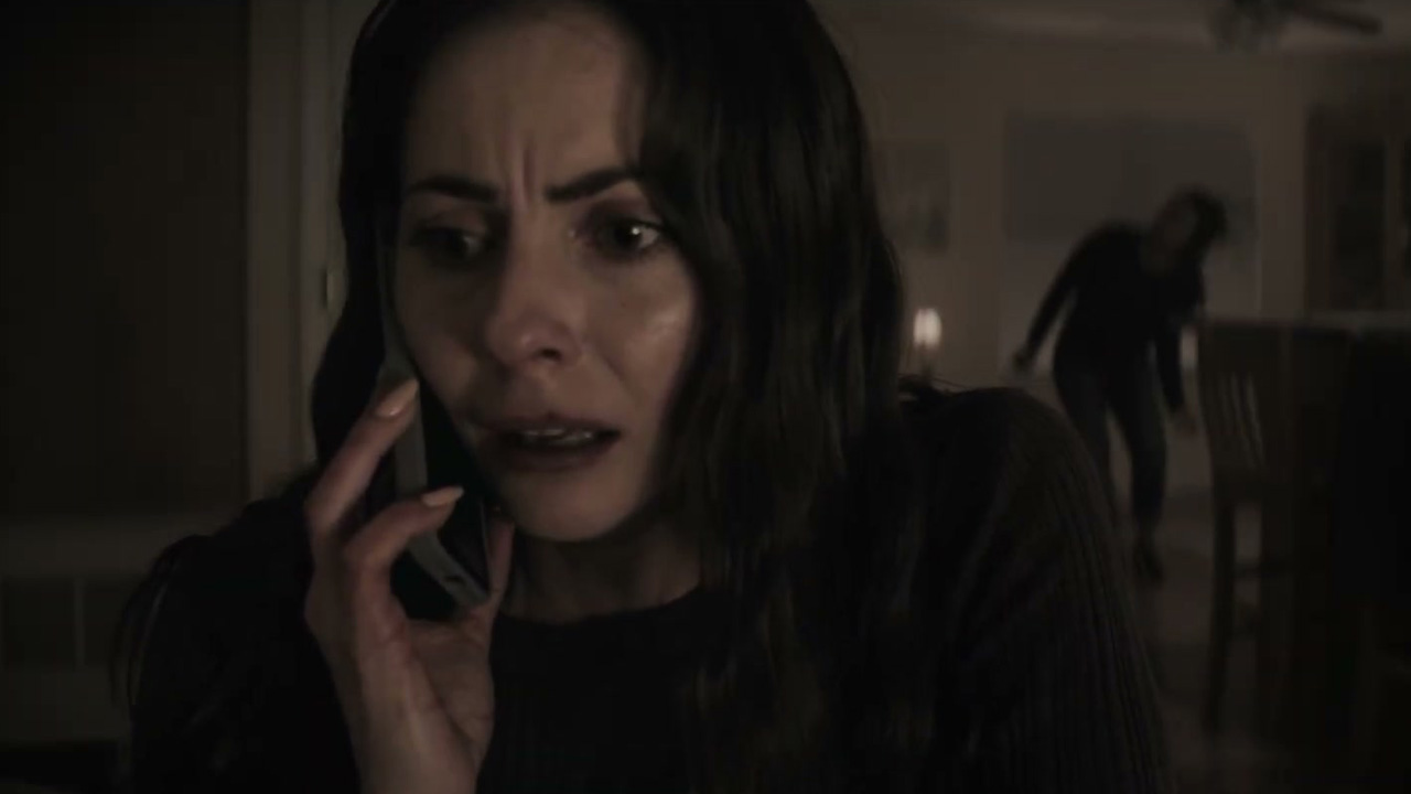 Willa Holland as Rebecca Owens on the phone while something lurks in the background behind her