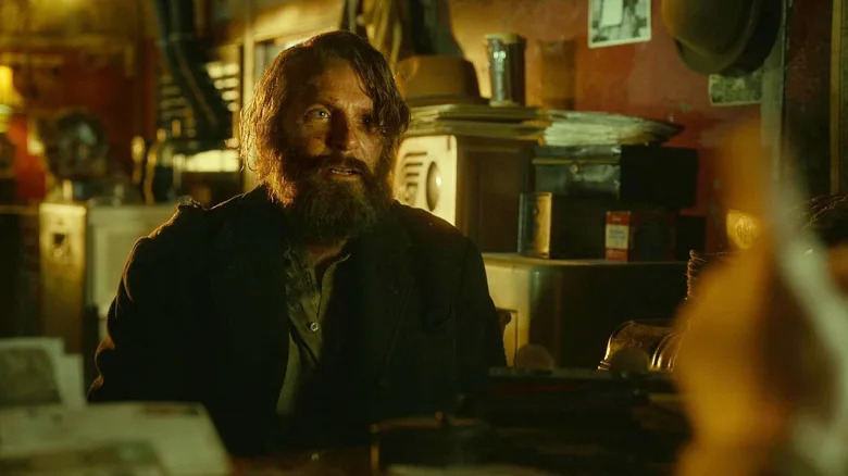 Bradley Cooper as Stan Carlisle looking bedraggled with a beard in Nightmare Alley