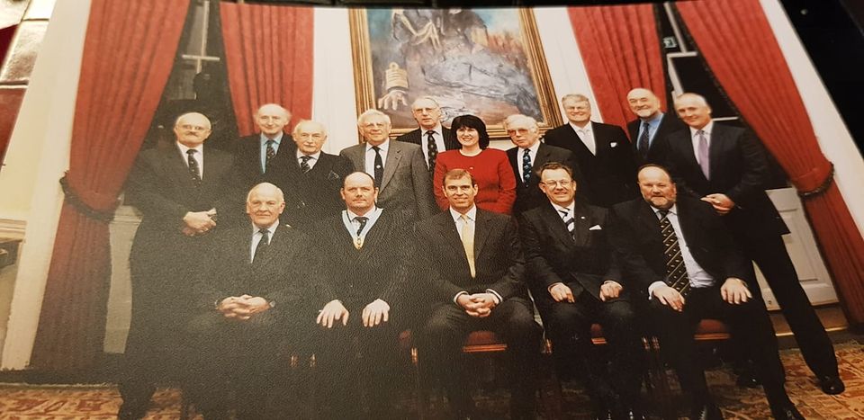 Sheila Bailey standing directly behind Andrew Mountbatten-Windsor.
