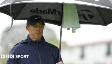 Rory McIlroy sheltering under an umbrella during round one of the Genesis Invitational