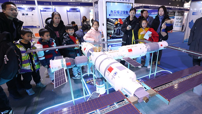 Visitors looking at a model of the Tianggong Space Station. Credit - CGTN / VCG