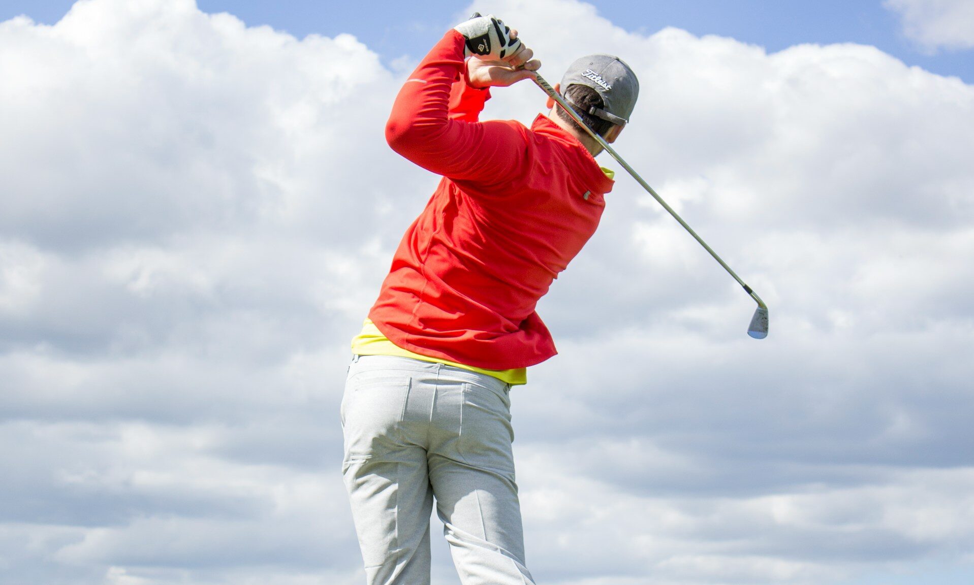 Man swinging golf club.