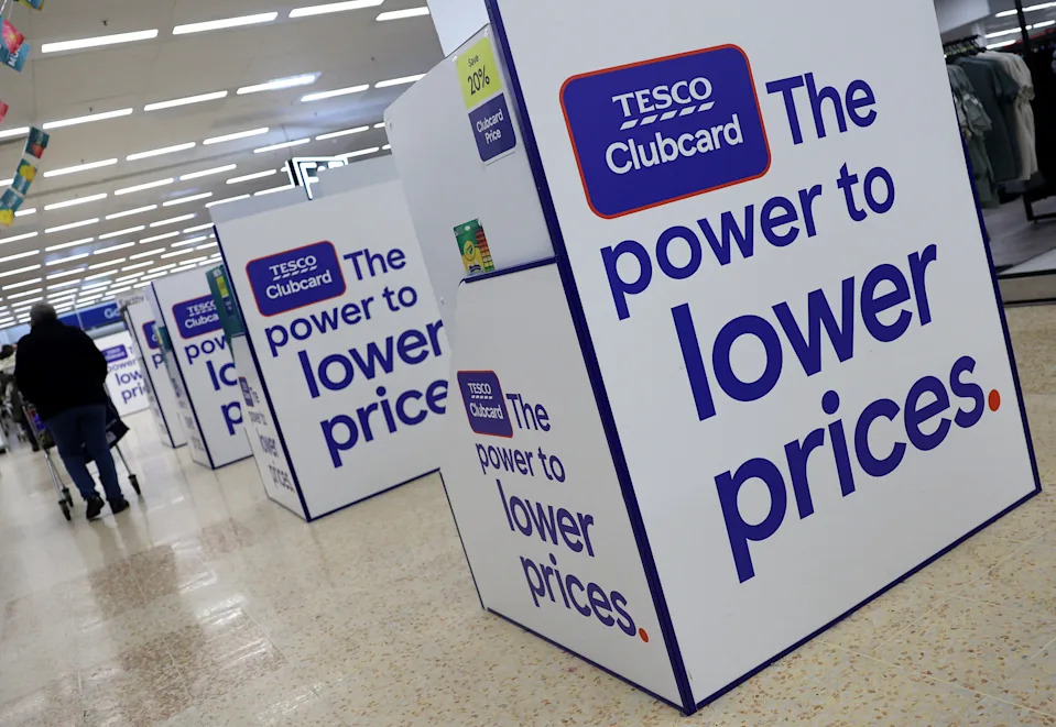 A shopper passes Tesco Clubcard signage at a Tesco Extra supermarket in Cheshunt, Britain, March 25, 2025. REUTERS/Toby Melville