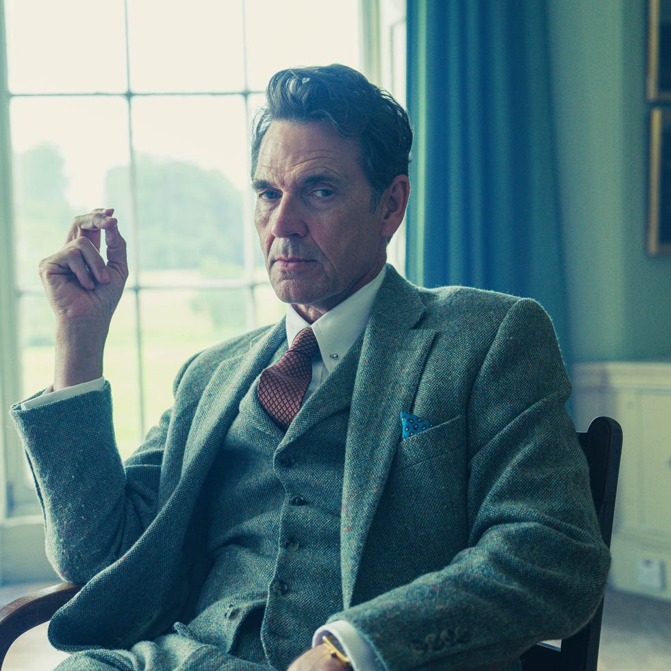 man seated indoors with a thoughtful expression