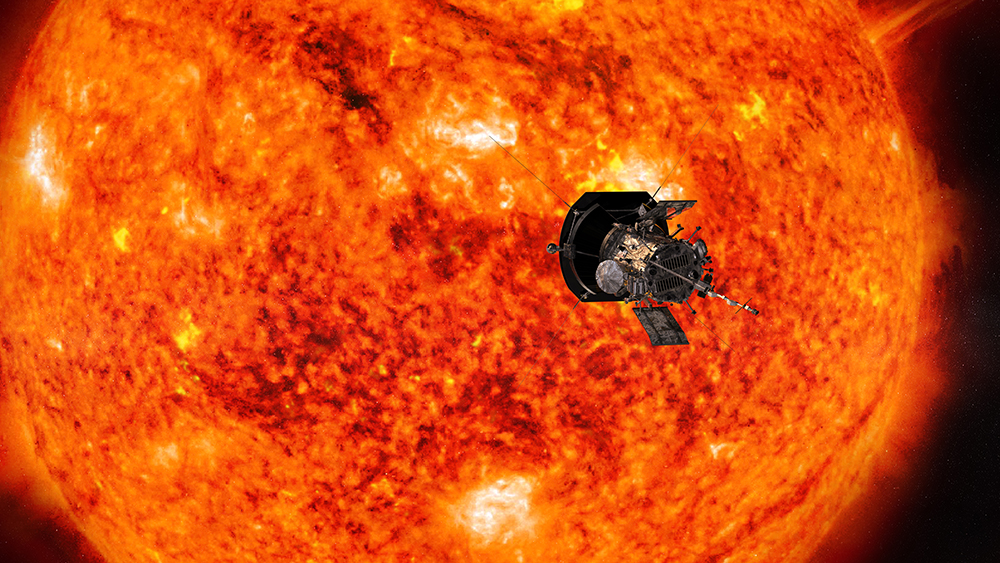 A spacecraft looks small in front of a scorching orange and yellow sun.