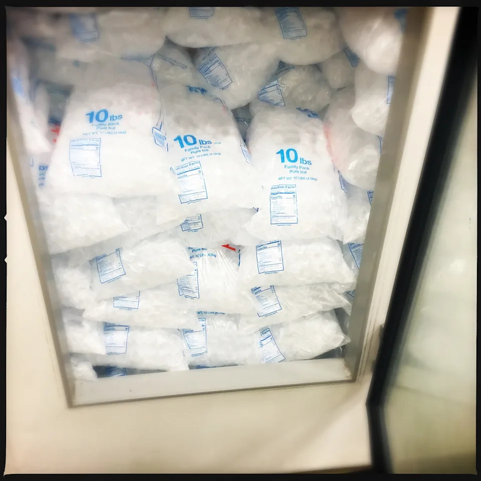 Ice bags stacked in a freezer, each labeled with "10 lbs."