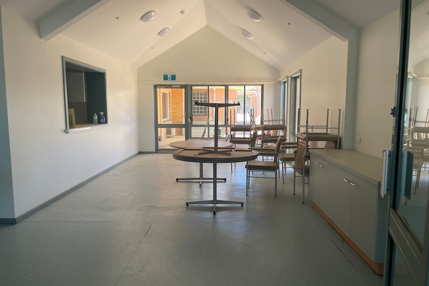 An empty hall with tables stacked on top of each other