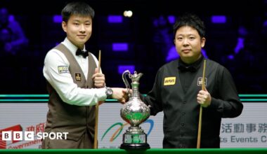 Zhao Xintong shakes the hand of Zhang Anda before the start of Sunday's World Grand Prix final in Hong Hong