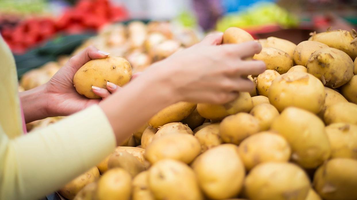 Woman buying potatoes from the produce market.
