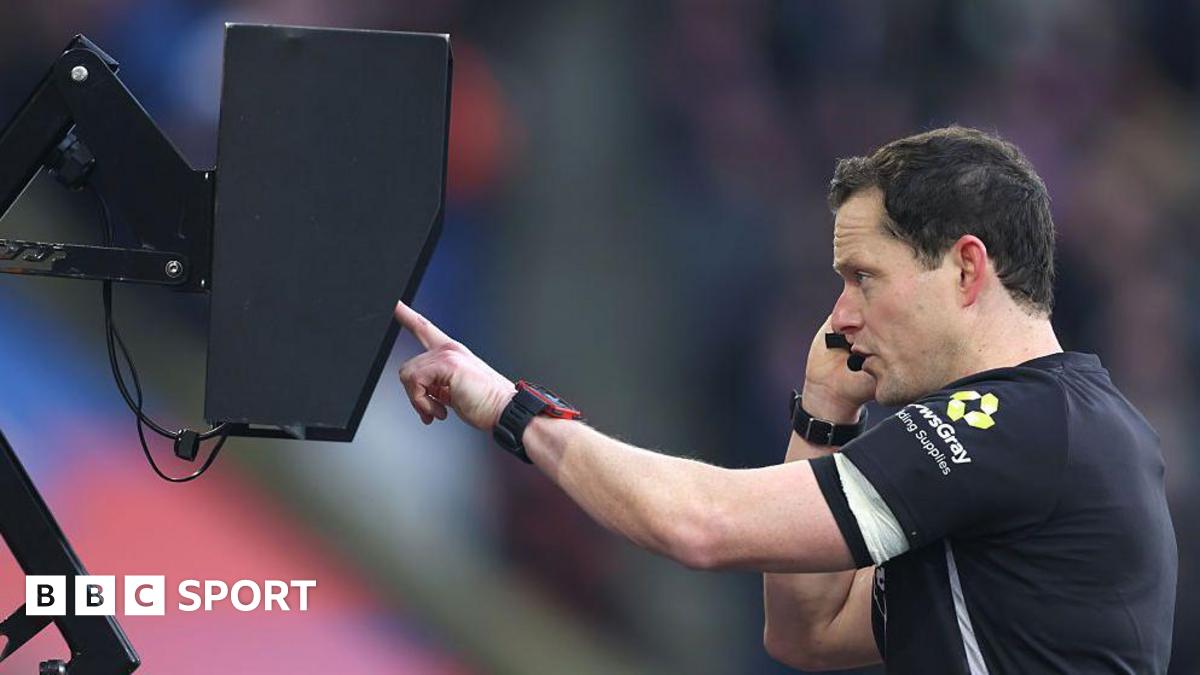 Darren England checks the VAR monitor pitchside