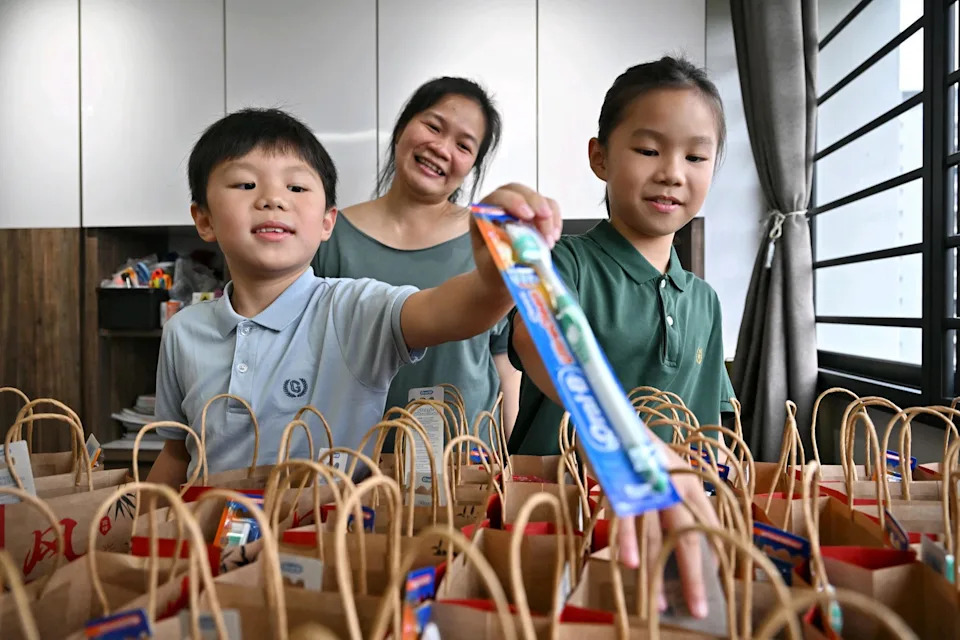 Ms Faith Ong and her children Kaizen (left) and Kay See preparing goodie bags in their home. The family started the initiative, called Little Hands, Big Hearts, to identify and address community needs. It has been granted up to $5,000 under the Our Singapore Fund.