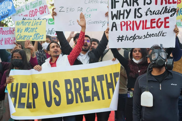 people carry signs at a protest