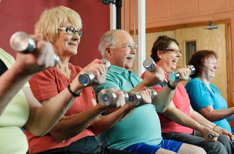 Older adults lifting light dumbbells.