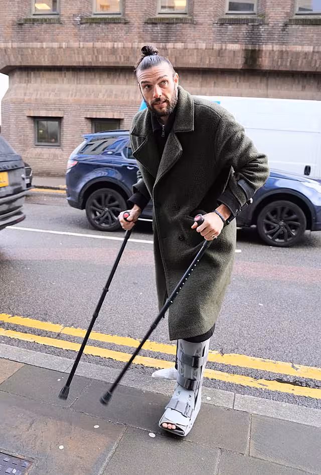 Andy Carroll pictured outside court, wearing a foot brace and using crutches