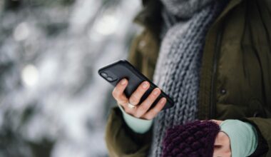 A person holding a smartphone in cold weather.