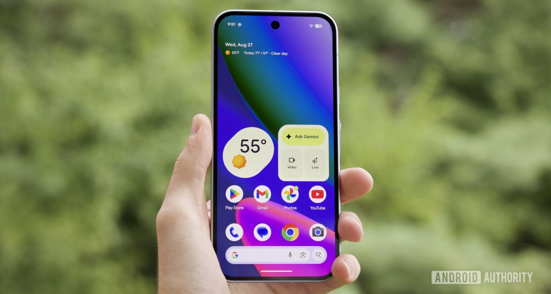 Someone holding the Google Pixel 10 with its screen on, showing the home screen.