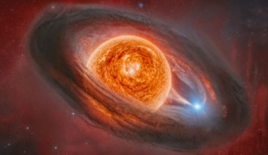 An illustration of an orange sphere in space surrounded by a gray ring of material.