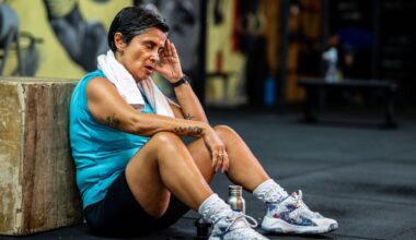 senior woman sits on the floor in the gym to take a rest