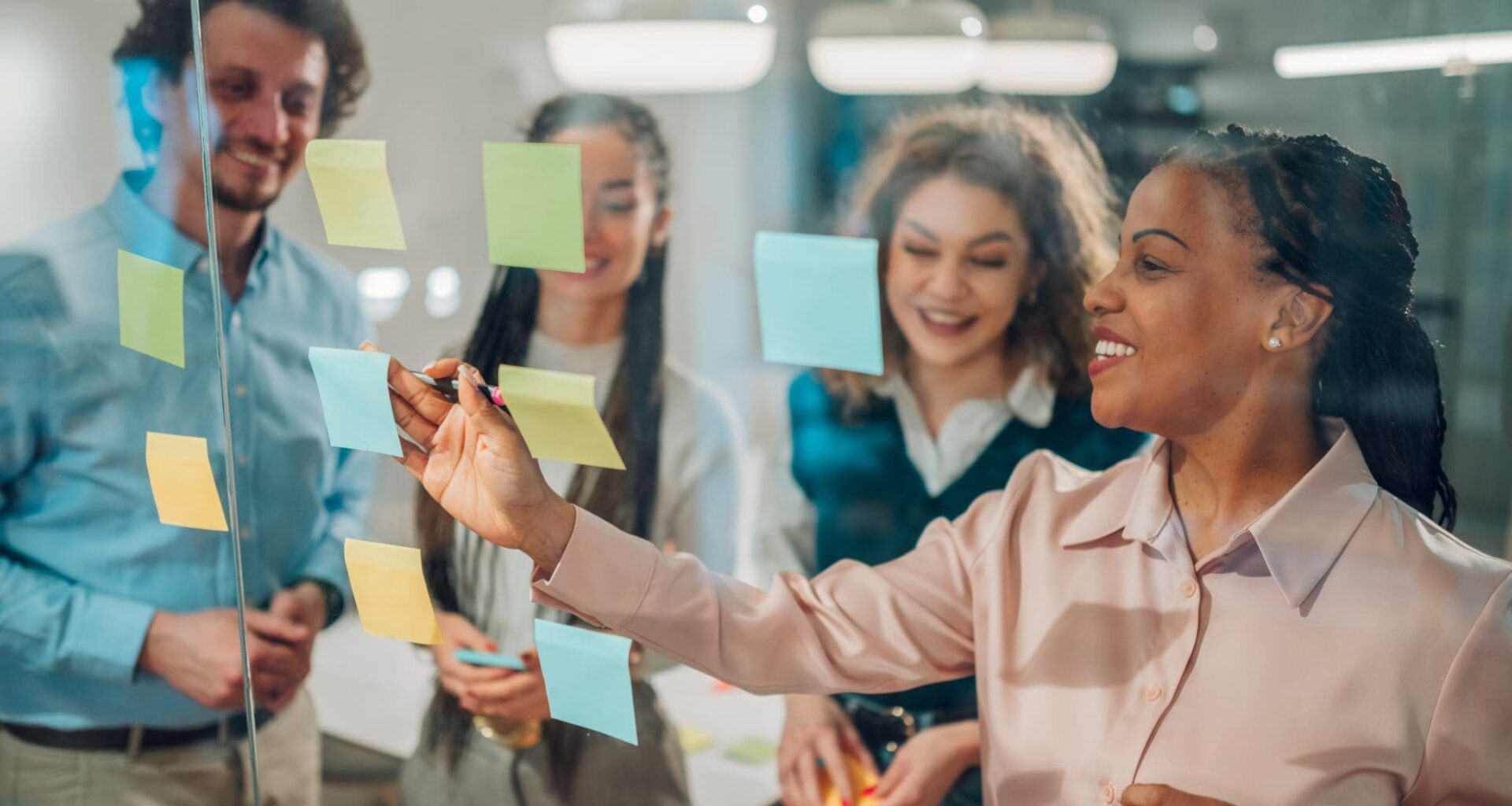 Businesswoman writing on sticky notes during a brainstorming session