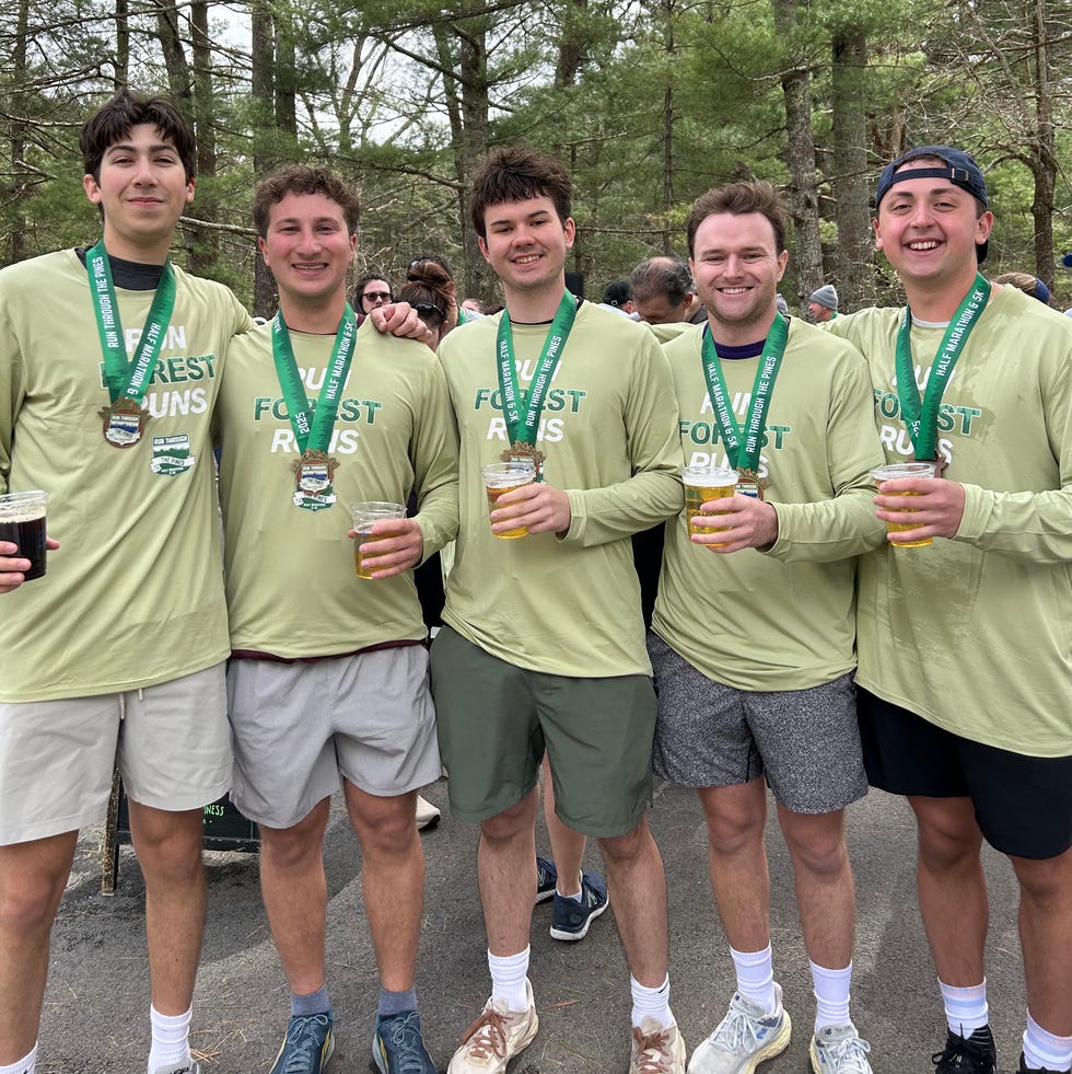 group of individuals holding drinks wearing matching shirts and medals