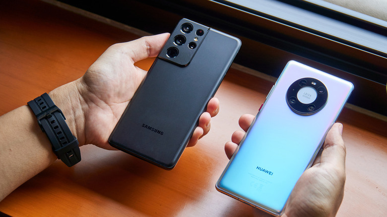 person comparing two android phone models