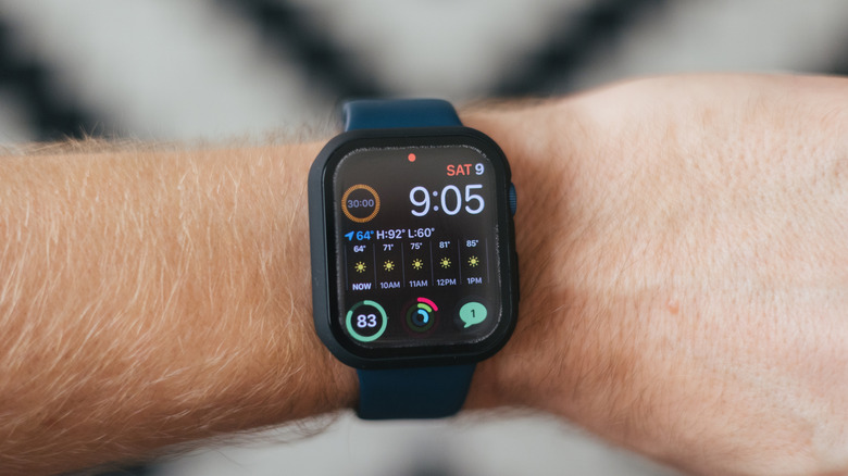 An Apple Watch model on hand with the Notification Inicator (red dot) at the top of the screen.