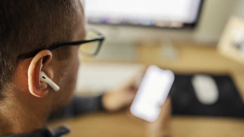 a man with a Bluetooth headphone in his ear