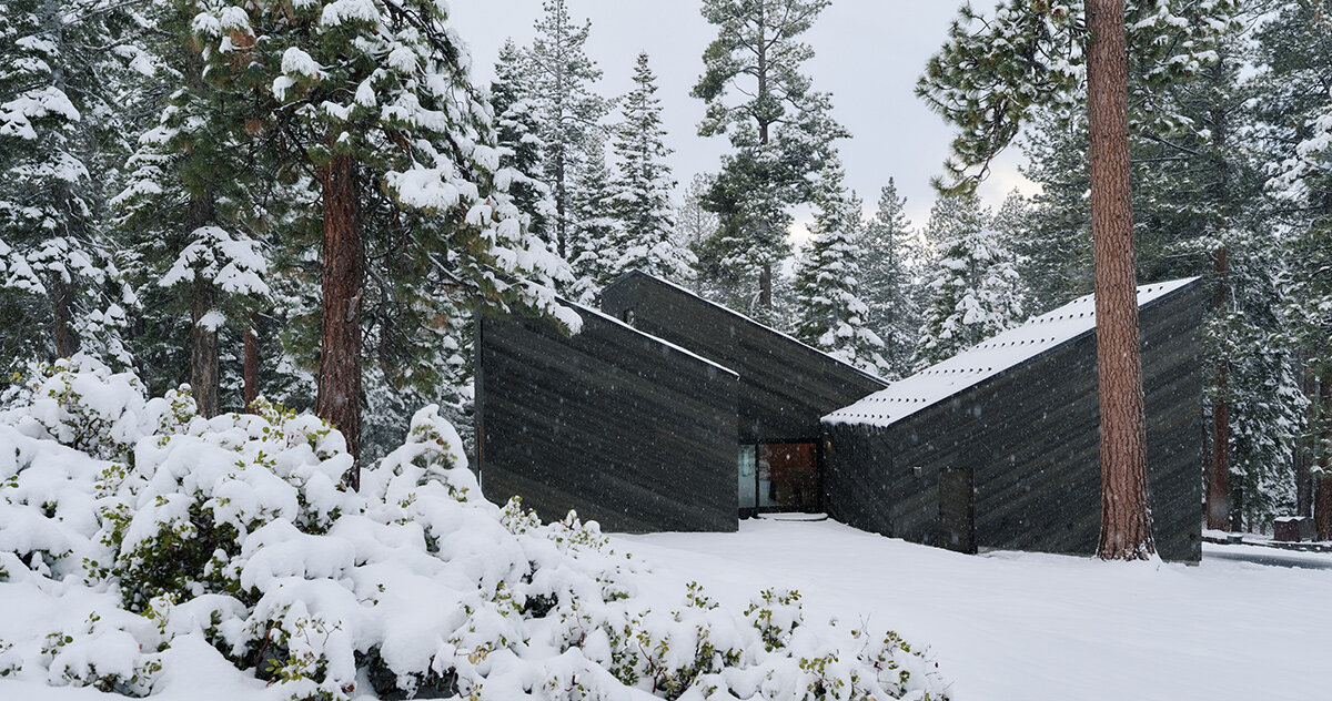cedar-clad 'staggered cabin' by mork-ulnes steps down a forested slope above lake tahoe