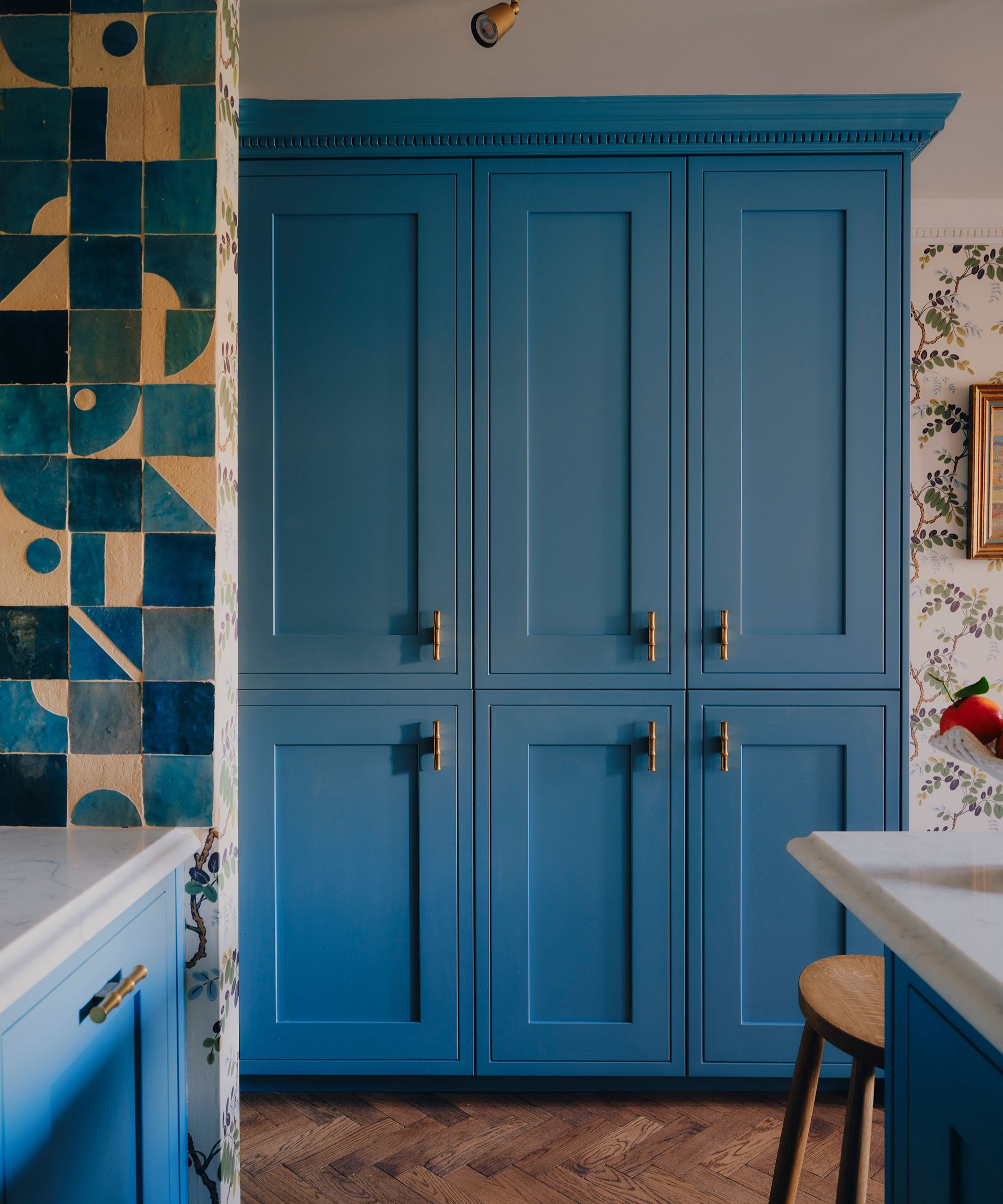 a bright blue kitchen in london with mix and match blue patterned zellige tiles