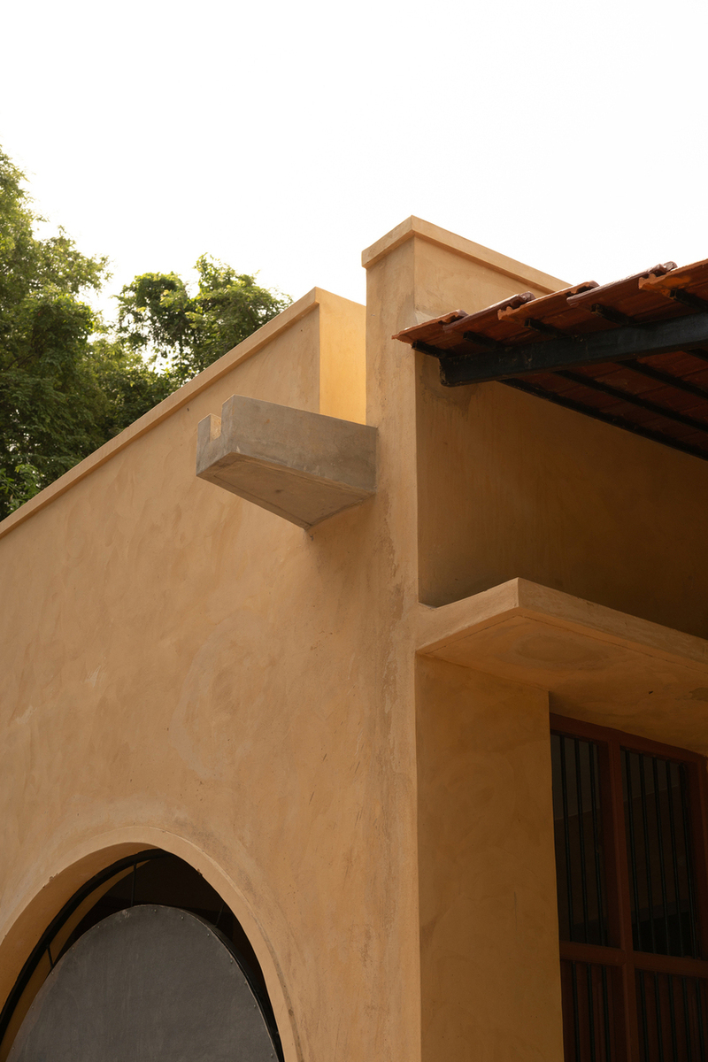 thousands of reclaimed bricks shape rural residence amid agricultural fields in india