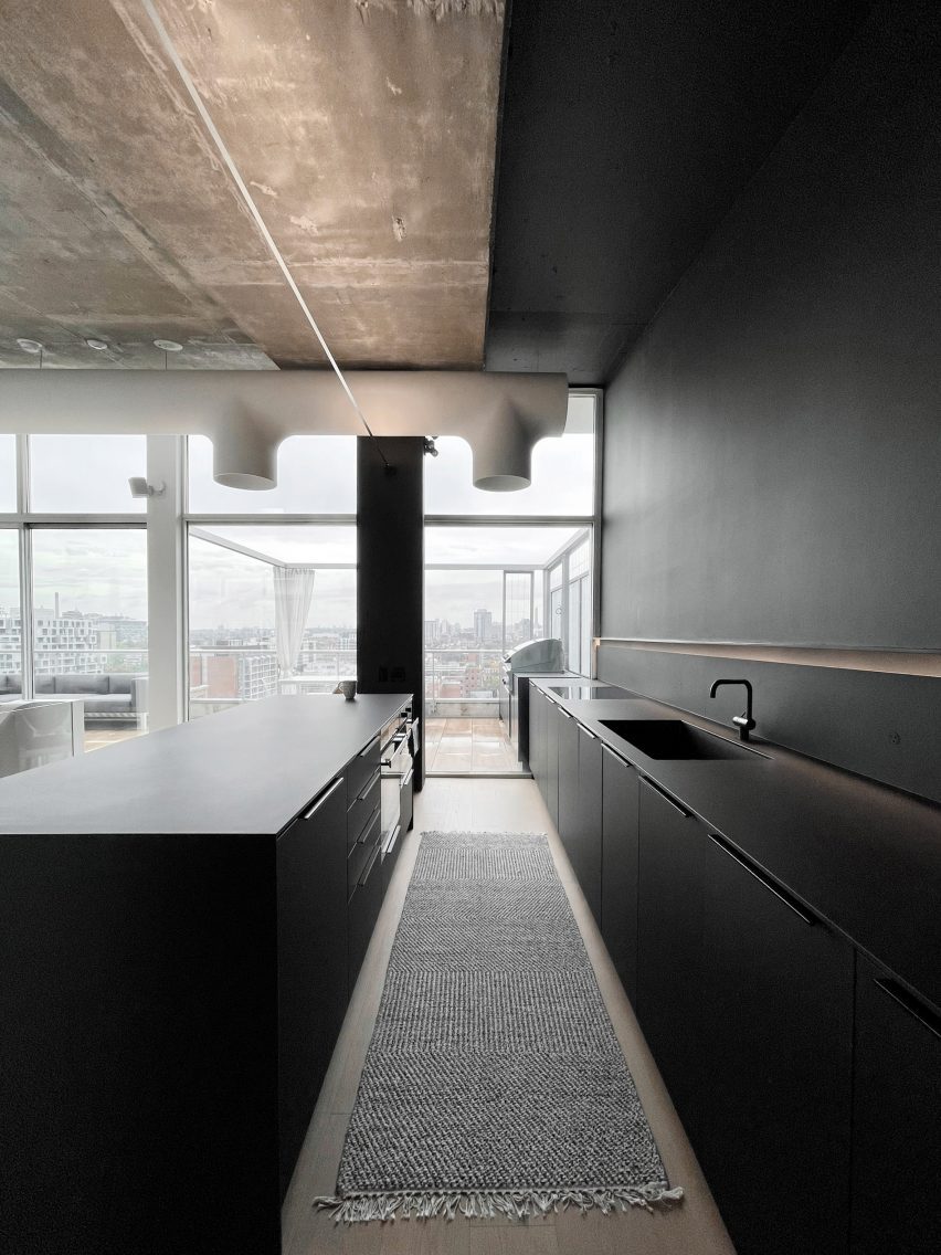 Black kitchen that opens onto a terrace via glass doors