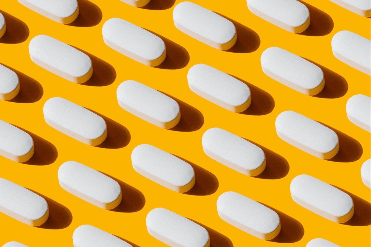 White pills in a yellow background