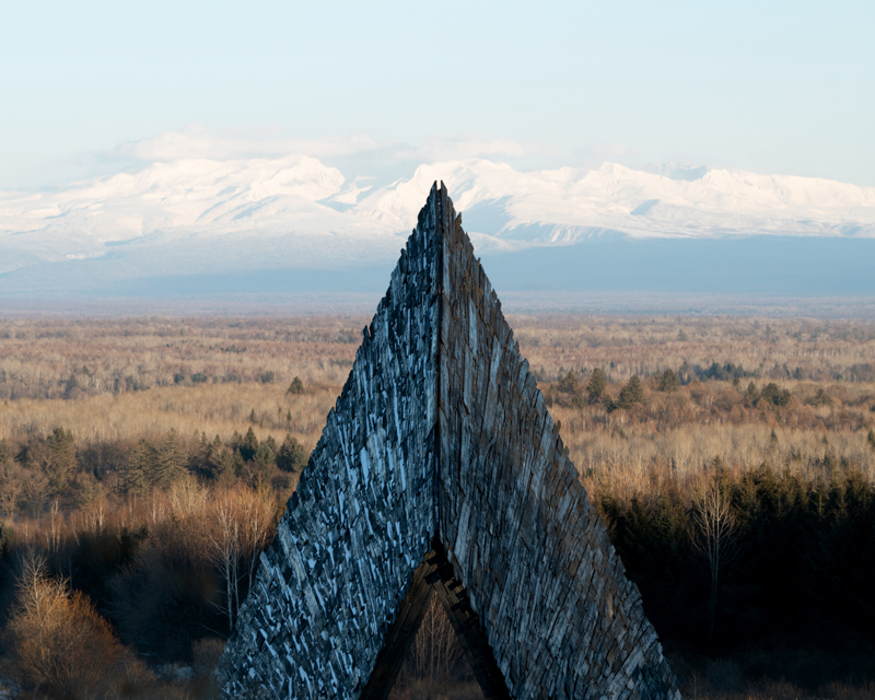 reflective red chamber emerges from prism mountain shelter’s charred wood shell
