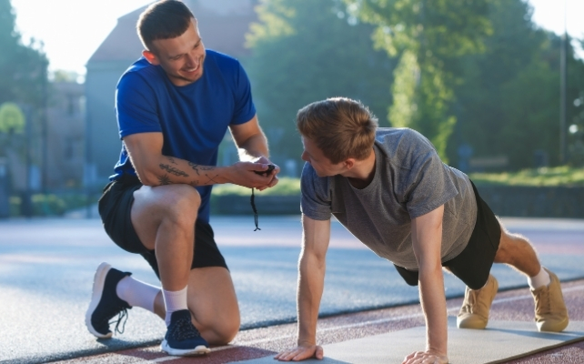 man doing push ups with a trainer