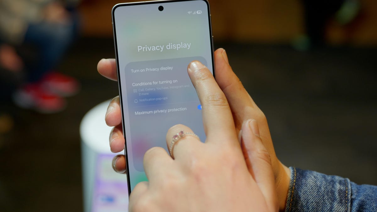 A person holding a Galaxy S26 Ultra points out the Privacy Display option.