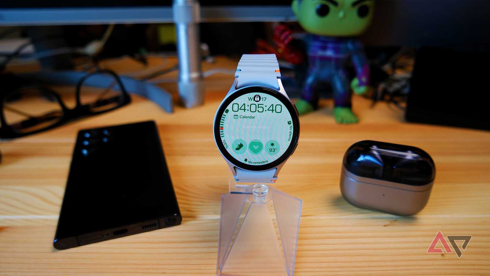 Samsung Galaxy Watch 7 on a watch stand with other Galaxy products in the background