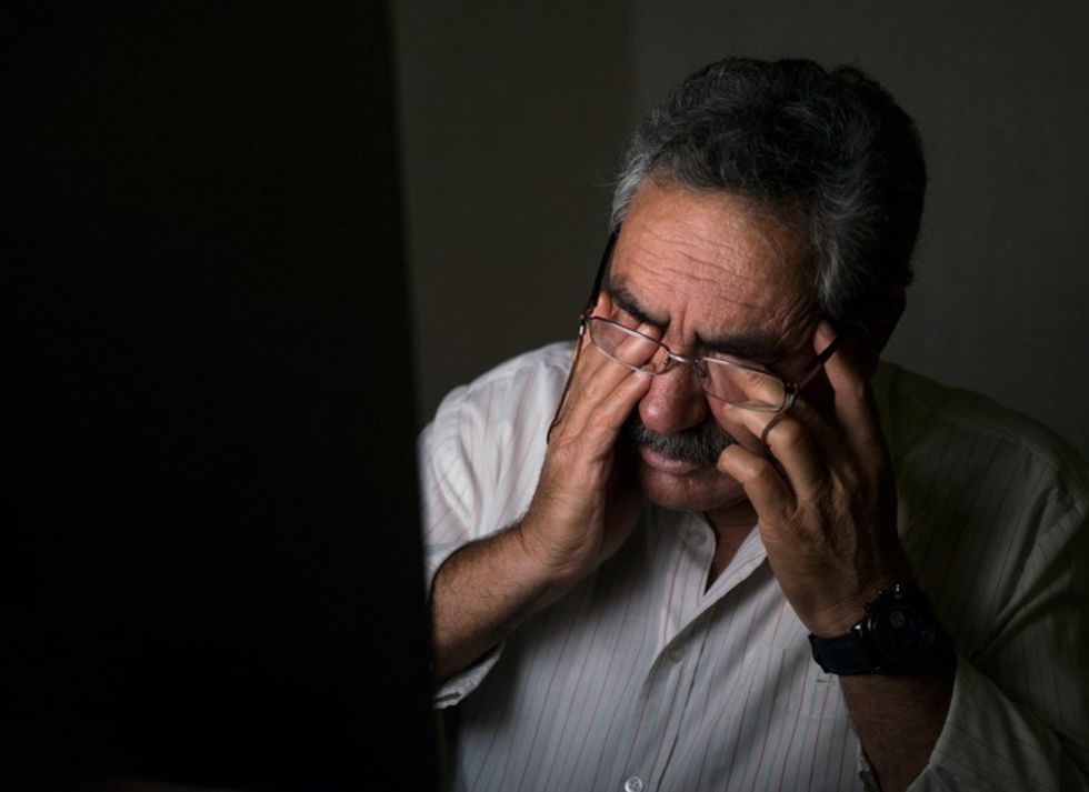 senior man rubbing eyes