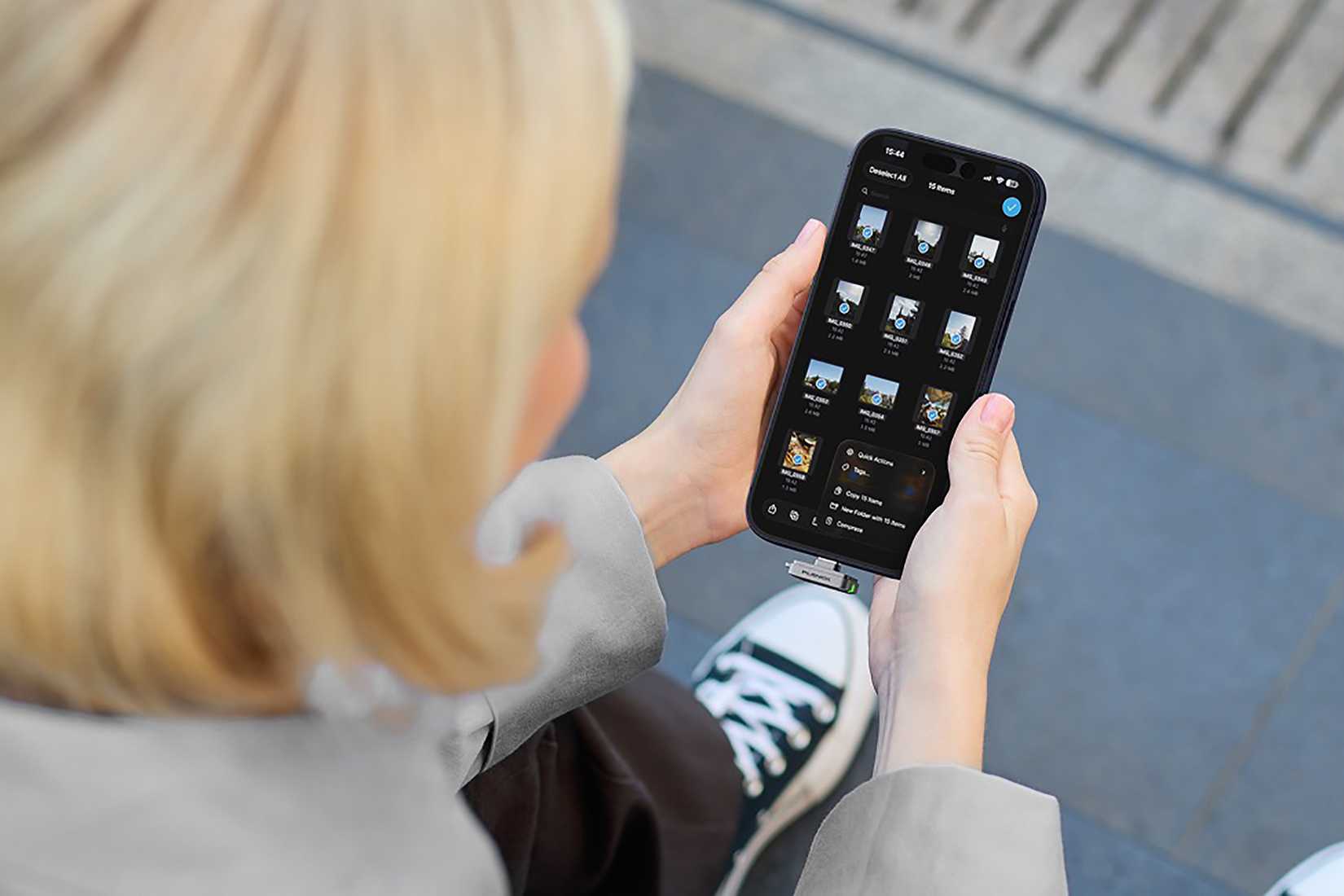 A woman holding her phone with the ShiftCam Planck Essential attached to it.