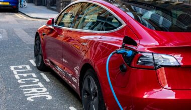 A red Tesla Model 3, with hidden door handles, parked and charging in a designated charging bay in central London. Pic: iStock
